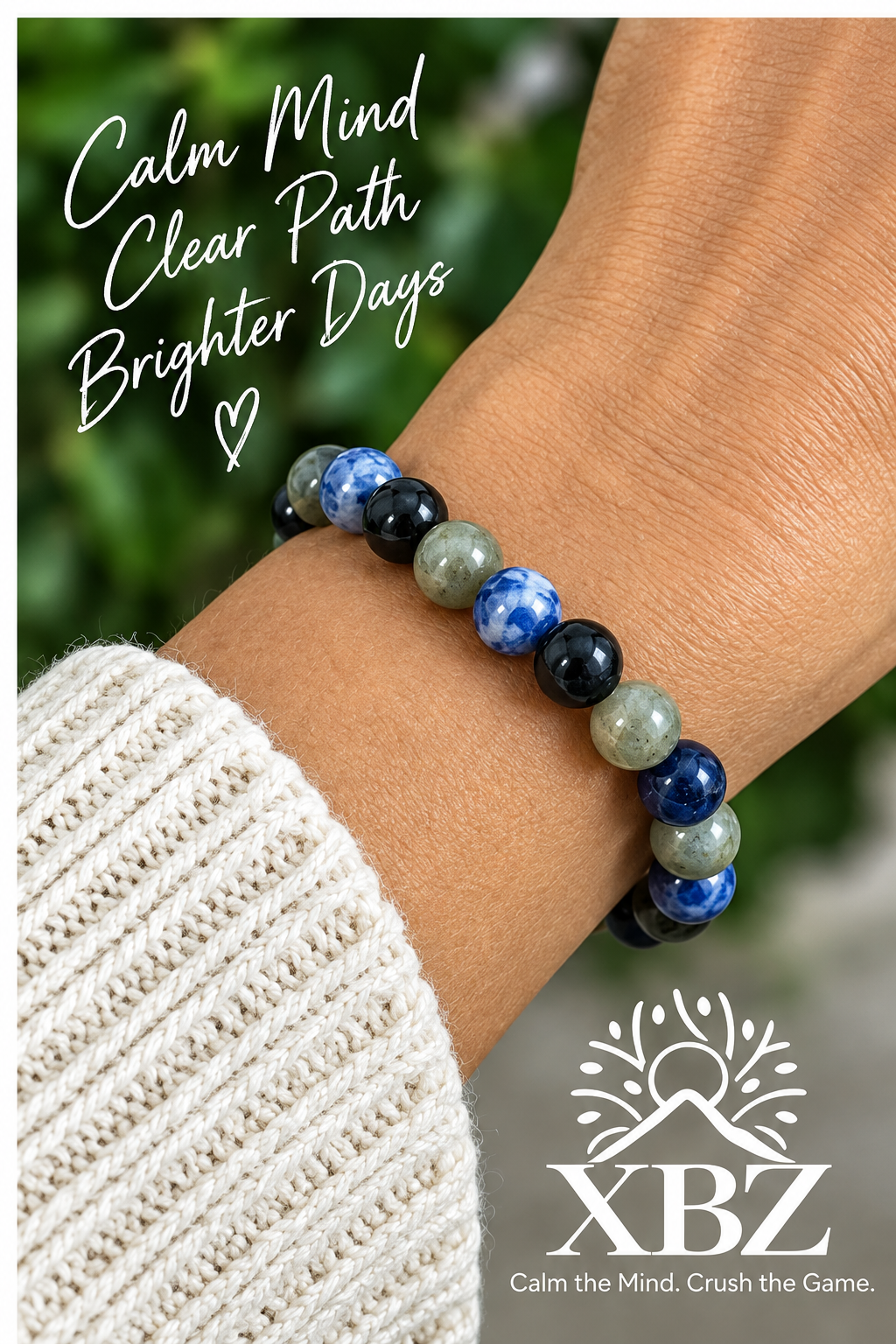 A close-up of a person's wrist wearing a beaded stretch bracelet made of blue, navy, white, and gray-green stones. The image includes promotional text reading 'Calm Mind Clear Path Brighter Days' and a logo for XBZ at the bottom right.