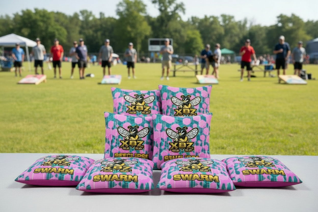 XBZ Swarm cornhole bags in pink and light blue drip, players in background