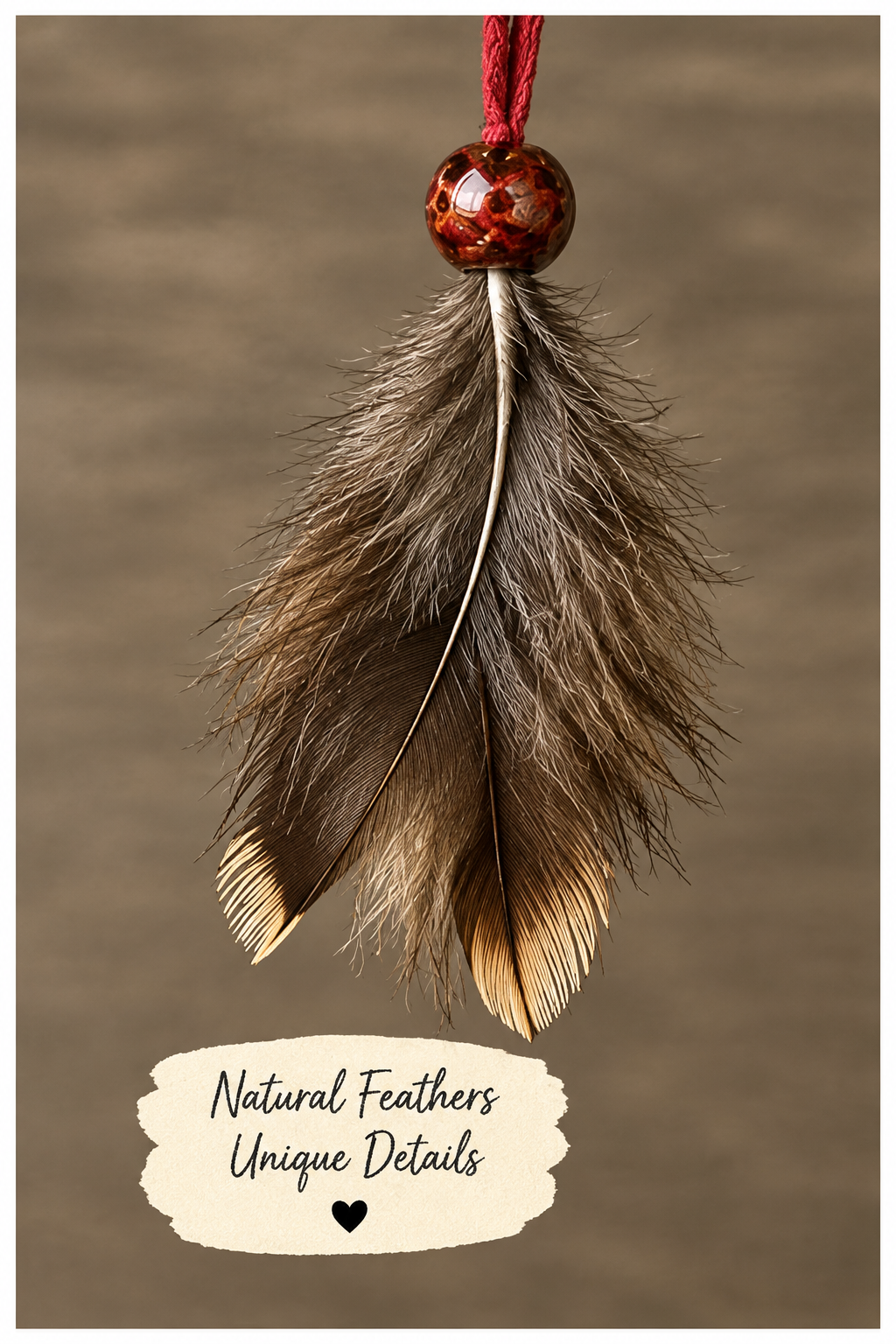 Two natural feather pendants hanging from red cords with black beads, shown against a blurred green background with a cream label reading 'Natural Feathers Unique Details'.